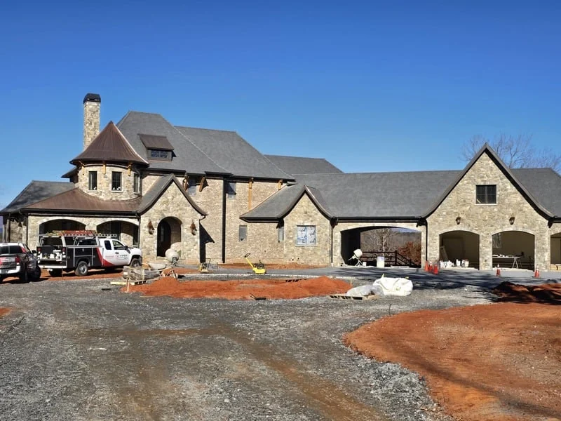Residential home under construction with a stone exterior